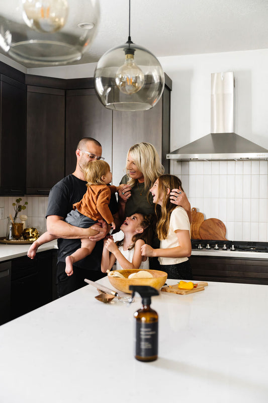 An O'Veda customer family using the Multi-Purpose Cleaner together in their kitchen