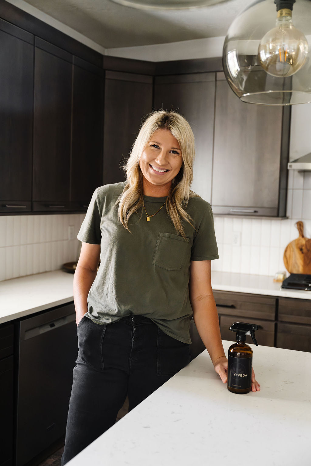 Sami, founder of O'Veda, reading a cleaning product ingredient label in her kitchen